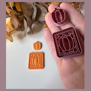 May include: A collection of pumpkin-themed cookie cutters in various sizes and shapes. The cutters are in shades of orange and burgundy, perfect for fall baking. One cutter is a pumpkin shape, and another is a pumpkin within a square frame.