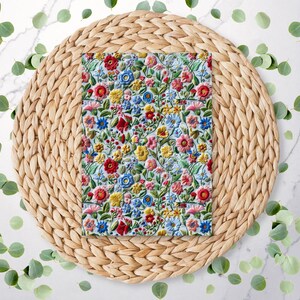 May include: A woven wicker placemat with a floral pattern fabric napkin on top. The napkin has a blue background with red, yellow, and blue flowers.