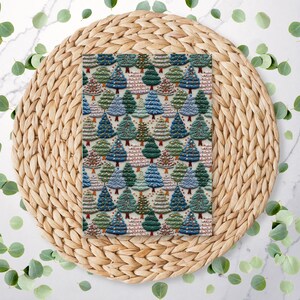 May include: A rectangular fabric with a repeating pattern of Christmas trees in shades of blue, green, and brown. The trees are decorated with small, colorful ornaments. The fabric is placed on a woven, circular placemat.