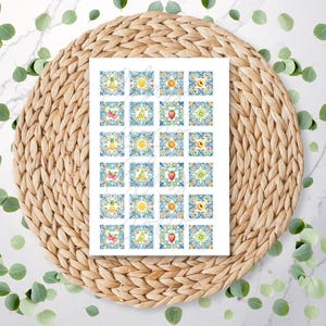 May include: A sheet of stickers with vibrant fruit designs, such as pineapples, cherries, and strawberries, on a blue and white patterned backdrop. The stickers are arranged in a grid, and the sheet is placed on a woven mat.