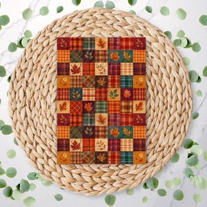 May include: A rectangular card featuring a patchwork grid design with alternating squares of autumn-themed patterns, including red, orange, and green plaid, solid colours, and detailed illustrations of various fall leaves in shades of gold and brown.