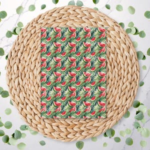 Peut inclure: Un tissu à motifs avec un motif aquarelle de tranches de pastèque et de feuilles vertes. Le tissu est placé sur un dessous de plat rond et tissé, entouré de feuilles vertes éparpillées. Le motif est un mélange vibrant de rouge, de vert et de blanc.