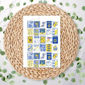 May include: A sheet of paper with various blue and yellow illustrations, including lemons and fish. The paper is on a woven, circular placemat, with green leaves scattered around it. The illustrations have text.