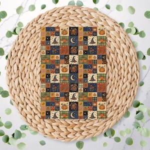 May include: A rectangular sheet of paper featuring a repeating patchwork grid pattern. The design includes squares with illustrations of orange pumpkins, dark blue witch hats, yellow crescent moons, and floral motifs in shades of orange, brown, and navy blue.