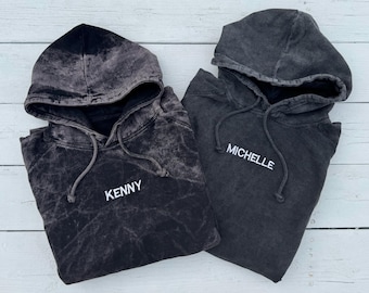 May include: Two black hooded sweatshirts with the names "Kenny" and "Michelle" embroidered on the front.