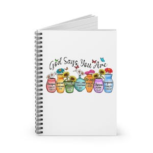 Puede incluir: Un cuaderno blanco con espiral con el texto "Dios dice que eres" e ilustraciones coloridas de jarrones con flores. Cada jarrón tiene una palabra y una referencia bíblica.