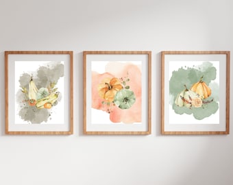 May include: Three watercolor prints featuring fall harvest gourds and pumpkins. The prints are framed in natural wood frames and have a white background with a watercolor wash of green, gray, or peach.