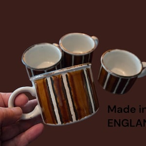 May include: Four ceramic mugs with a brown and white striped design. The mugs have white handles and interiors. The text "Made in ENGLAND" is visible. The mugs are suitable for coffee, tea, or other beverages.
