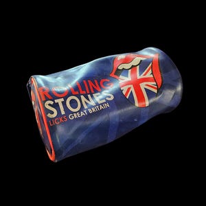 May include: A blue Rolling Stones branded case featuring the red tongue logo and a Union Jack design. The text "Rolling Stones Licks Great Britain" is printed on the case.