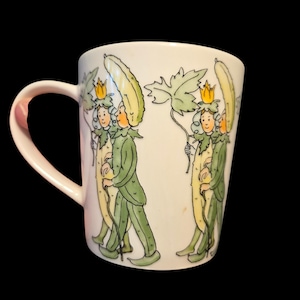 May include: White ceramic mug with a repeating illustration of figures in green and yellow cucumber costumes, carrying leaves and walking with canes. The design wraps around the mug, which has a curved handle on the left side.