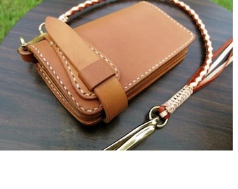 May include: A brown leather wallet with a braided leather strap and a brass clasp. The wallet has multiple compartments and is stitched with white thread.