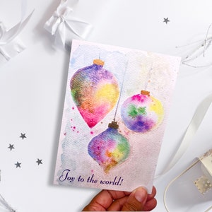 Alegría brillante para el mundo - Tarjeta de felicitación de acuarela pintada a mano con adornos multicolores Tarjeta de notas en blanco de Navidad idea de regalo festivo