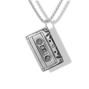 May include: A silver-coloured pendant shaped like a vintage cassette tape, featuring detailed engravings of the two circular spools and the central magnetic tape window. The pendant hangs from a matching silver-coloured box chain necklace.