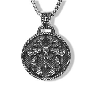 Könnte beinhalten: Silberfarbene Halskette mit Anhänger, die einen detaillierten runden Anhänger mit einem Drachenmotiv aufweist. Der Anhänger hat einen strukturierten Rand und ist an einer Kette befestigt. Das Drachendesign ist aufwendig und der Stil ist gotisch.