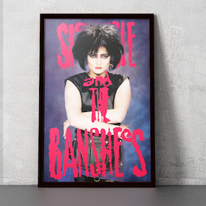 May include: A vintage concert poster featuring a black and white photo of Siouxsie Sioux, the lead singer of Siouxsie and the Banshees, with the band's name in pink lettering.