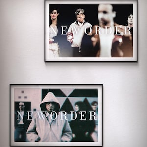 May include: Two black framed posters with the band name "NEW ORDER" in white text. The top poster shows four people in a blurry background. The bottom poster shows a person wearing a hooded jacket in a blurry background.