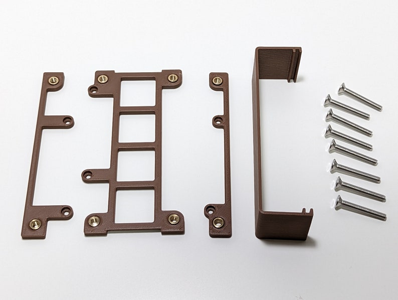 Puede incluir: Un conjunto de piezas de pl&aacute;stico marr&oacute;n para un proyecto de impresi&oacute;n 3D, que incluye cuatro piezas rectangulares con agujeros y una pieza rectangular m&aacute;s larga. El conjunto tambi&eacute;n incluye ocho tornillos plateados.