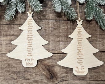 May include: Two light-colored wooden Christmas tree ornaments with twine hangers. Each ornament features a list of names engraved in the center, topped with a star. The left ornament reads Mrs. Lee 2nd grade 2025/2026, and the right reads Ms. Fox Kindergarten 2025/2026.