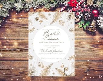 Puede incluir: Una invitación de ducha nupcial blanca con ramas de pino doradas y copos de nieve. El texto dice "Por favor, únase a nosotros para una ducha nupcial en honor a Madeline Smith Domingo, 15 de diciembre 12PM-3PM The Smith Residence 345 Holly Lane Chicago, Illinois RSVP a Julia (555)-314-0307"