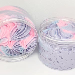 May include: Two clear jars filled with a swirl of pink and purple whipped body butter.