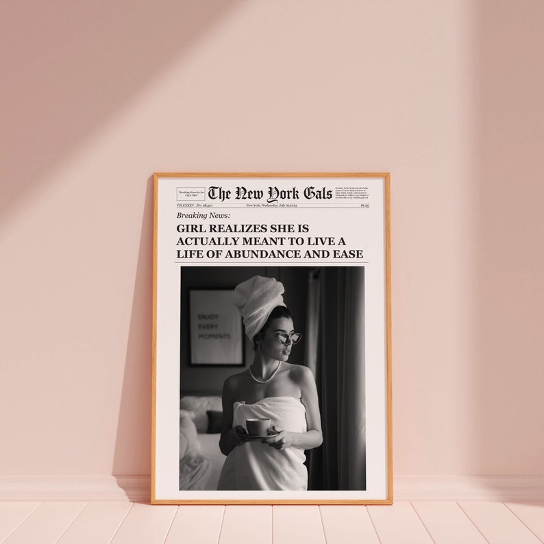 Pu&ograve; includere: Stampa di giornale in bianco e nero con un titolo che recita "GIRL REALIZES SHE IS ACTUALLY MEANT TO LIVE A LIFE OF ABUNDANCE AND EASE". L'immagine mostra una donna avvolta in un asciugamano bianco, che tiene una tazza, in piedi davanti a una finestra. Il testo "ENJOY EVERY MOMENT" &egrave; visibile su una superficie sullo sfondo.