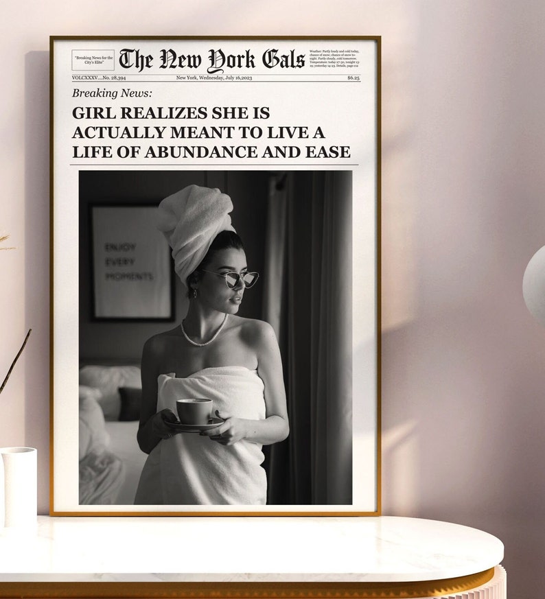 Pu&ograve; includere: Una fotografia in bianco e nero di una donna avvolta in un asciugamano bianco, che tiene una tazza di caff&egrave;. La foto &egrave; incorniciata e ha un titolo di giornale che recita "GIRL REALIZES SHE IS ACTUALLY MEANT TO LIVE A LIFE OF ABUNDANCE AND EASE".