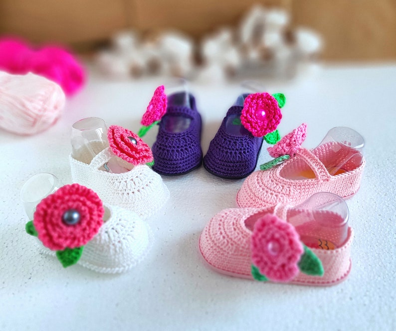 Pu&ograve; includere: Quattro paia di scarpine per neonati all'uncinetto con decorazioni floreali. Due paia sono bianche con fiori rosa, un paio &egrave; viola con un fiore rosa e un paio &egrave; rosa con un fiore rosa.