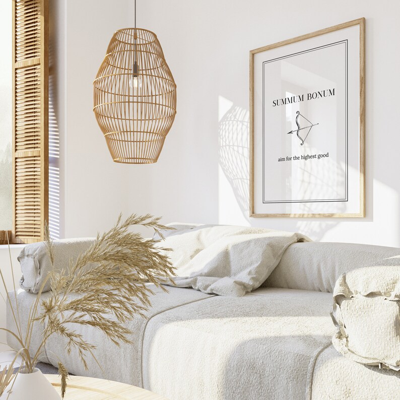 May include: A white couch with pillows and a throw blanket in a living room with a wooden framed print that reads "Summum Bonum aim for the highest good" and a woven pendant light hanging from the ceiling.