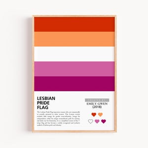 May include: A framed print of the Lesbian Pride Flag, with horizontal stripes in shades of orange, white, pink, and dark rose. The text "LESBIAN PRIDE FLAG" is below the flag, with the creator's name and year. A widely recognised symbol of lesbian pride and identity.