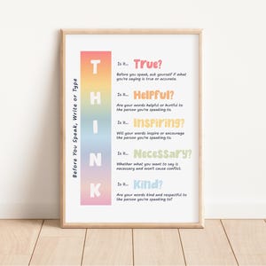 May include: A framed poster with the word "THINK" in colorful vertical blocks. The poster includes questions to consider before speaking, such as "Is it True?" and "Is it Kind?" The poster is displayed on a wooden floor.