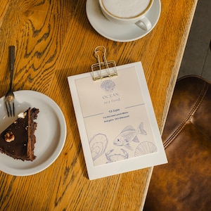 Personalized wood menu stand featuring a black binder clip, crafted for displaying menus at modern restaurants or upscale events.