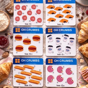May include: A selection of cards featuring illustrations of pastries and coffee, with the text "OH CRUMBS" and "www.ETSY.COM SHOP PROJECTTEDCO". The cards show donuts, croissants, and coffee cups. The cards are surrounded by various baked goods.