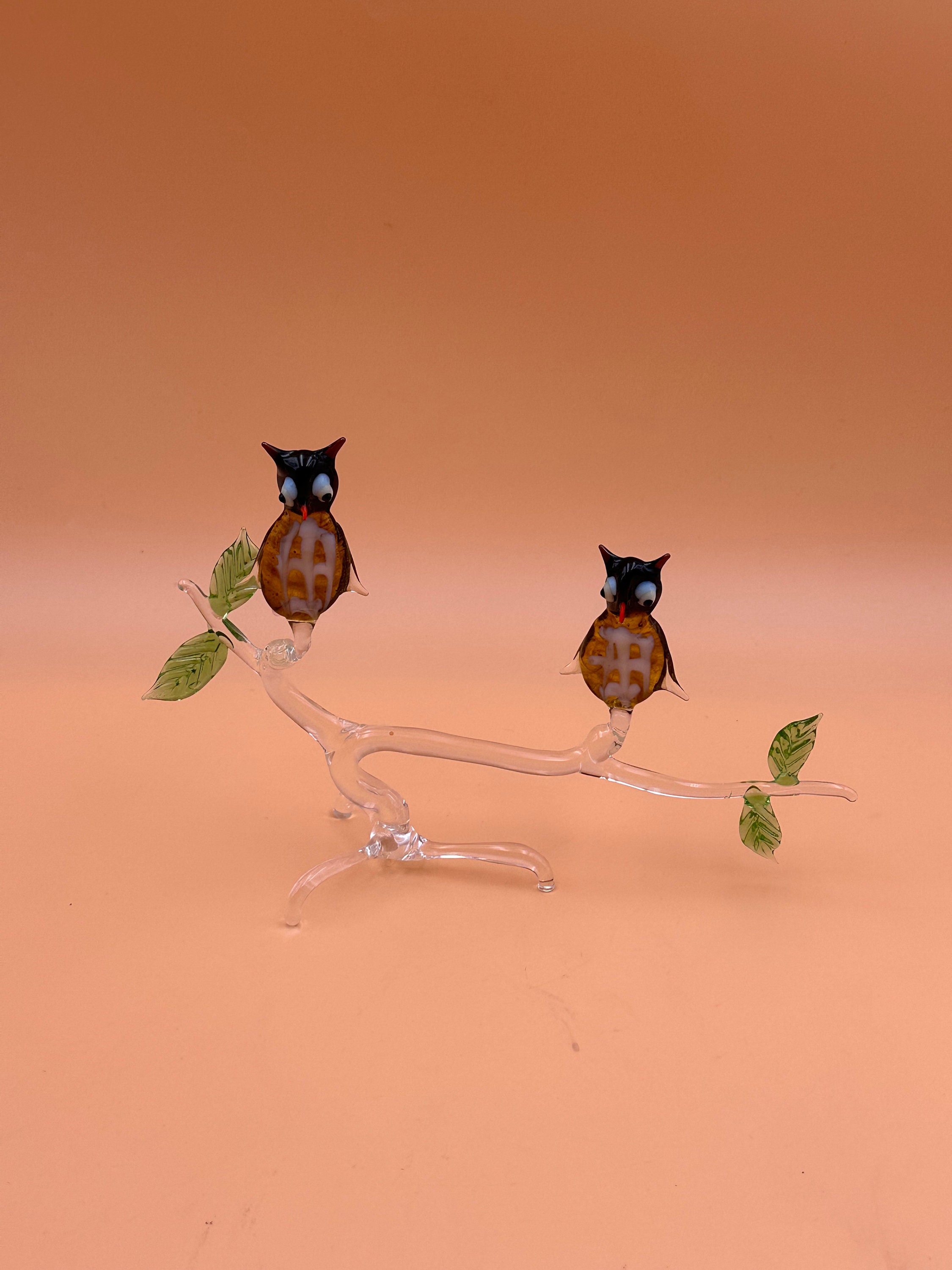 blown glass owls sitting on a branch