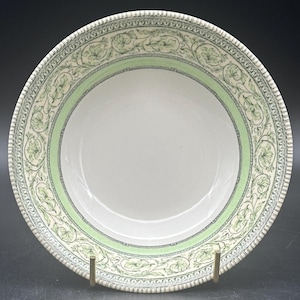 May include: A white ceramic bowl with a green and white floral pattern around the rim.