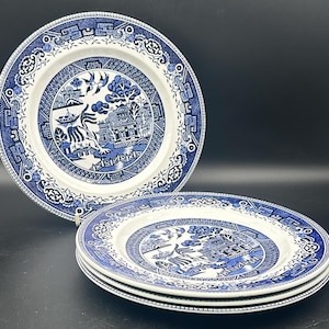 May include: Three blue and white ceramic dinner plates with a willow pattern design. The plates are stacked on top of each other.
