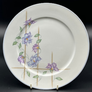 Peut inclure: Assiette plate en céramique blanche avec un motif floral bleu et violet. Les fleurs sont disposées en treillis avec des lignes dorées.