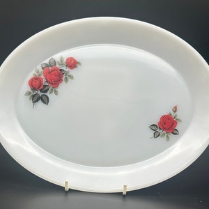 May include: White oval serving platter with a red rose floral design.