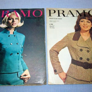Könnte beinhalten: Zwei Vintage-Modezeitschriften mit dem Wort „PRAMO“. Auf dem einen Cover ist eine Frau in einem tealfarbenen Anzug zu sehen, auf dem anderen eine Frau in einem braunen Tweed-Anzug. Beide Zeitschriften liegen auf einer blauen Oberfläche.
