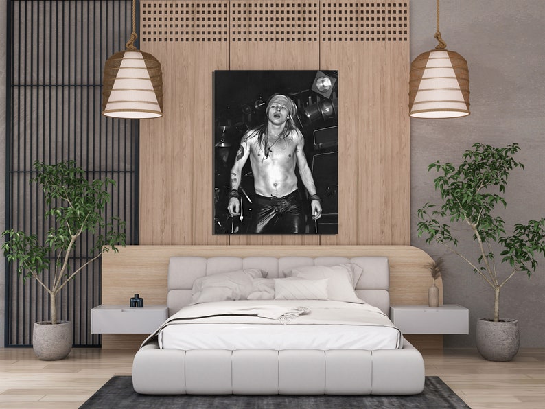 K&ouml;nnte beinhalten: Schwarzwei&szlig;foto eines oben ohne Mannes mit langen Haaren und einem Bandana, der vor einem Mikrofon steht. Das Foto ist gerahmt und h&auml;ngt an einer Wand in einem modernen Schlafzimmer mit einem wei&szlig;en Bett, einem Holz-Kopfteil und zwei H&auml;ngelampen.