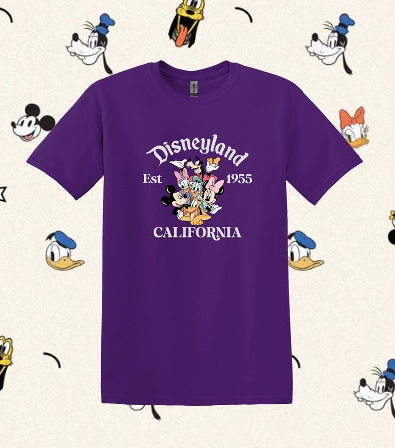 May include: Purple t-shirt with a white graphic of Mickey Mouse, Minnie Mouse, Donald Duck, Goofy, and Pluto. The graphic includes the text "Disneyland Est 1955 CALIFORNIA".