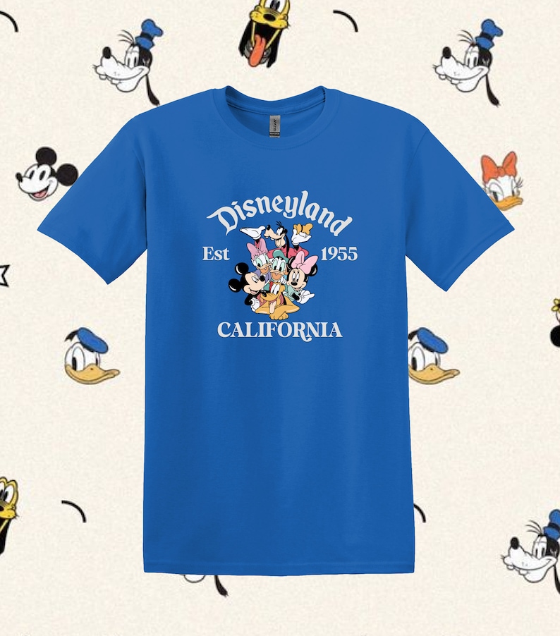 May include: A royal blue t-shirt with a white graphic of Mickey Mouse, Minnie Mouse, Donald Duck, Goofy, and Pluto. The graphic includes the text "Disneyland Est 1955 California".