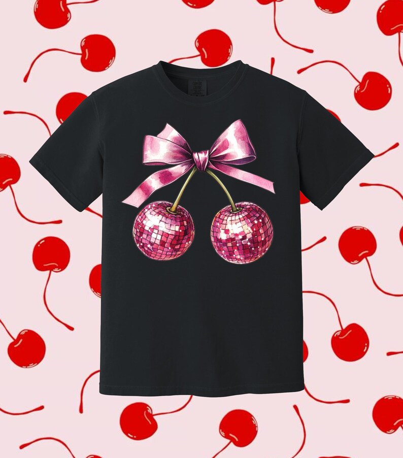 May include: Black t-shirt featuring a pink bow and two cherries with a sparkly pink design.