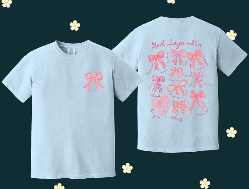 May include: Two light blue t-shirts with pink bows and the text "God says I'm" with a list of positive words around the bows on the back.