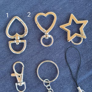 May include: A white ceramic mug with a black handle and the text "But First, Coffee" in a black, bold font. The mug is on a white surface. The mug is approximately 4 inches tall.