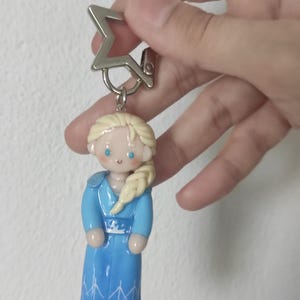 May include: A white ceramic mug with a black handle and the text "But First, Coffee" in a bold, black font. The mug is set against a blurred background, suggesting a cozy setting.