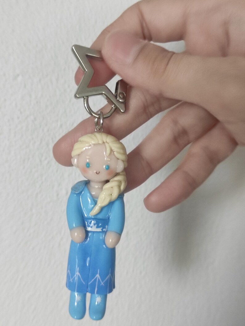 May include: A white ceramic mug with a black handle and the text "But First, Coffee" in a bold, black font. The mug is set against a blurred background, suggesting a cozy setting.