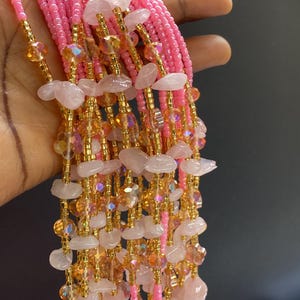 May include: A pink and gold beaded waist chain with rose quartz and crystal beads.