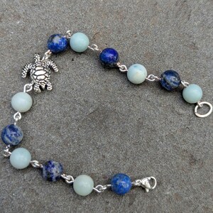 Bracciale artigianale in amazzonite e lapislazzuli con ciondolo a forma di tartaruga marina in argento.