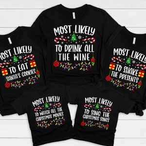 May include: Five black t-shirts with white text and Christmas-themed graphics. The shirts read "Most Likely to Eat Santa's Cookies", "Most Likely to Drink All the Wine", "Most Likely to Shake the Presents", "Most Likely to Watch All the Christmas Movies", and "Most Likely to Sing the Christmas Songs".