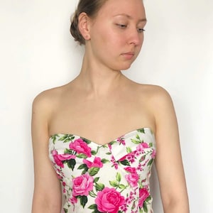 May include: A strapless white and pink floral print corset top.